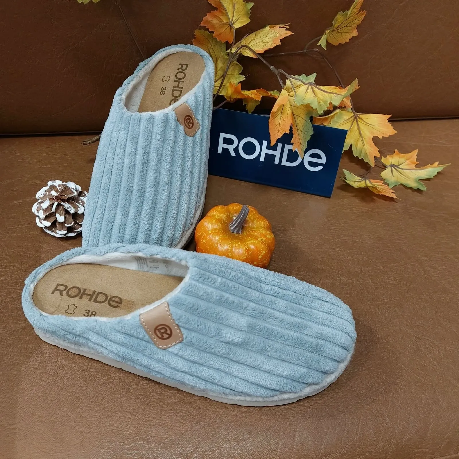 Lichtblauwe Rohde-pantoffels van ribstof met kurkvoetbed, tussen herfstbladeren